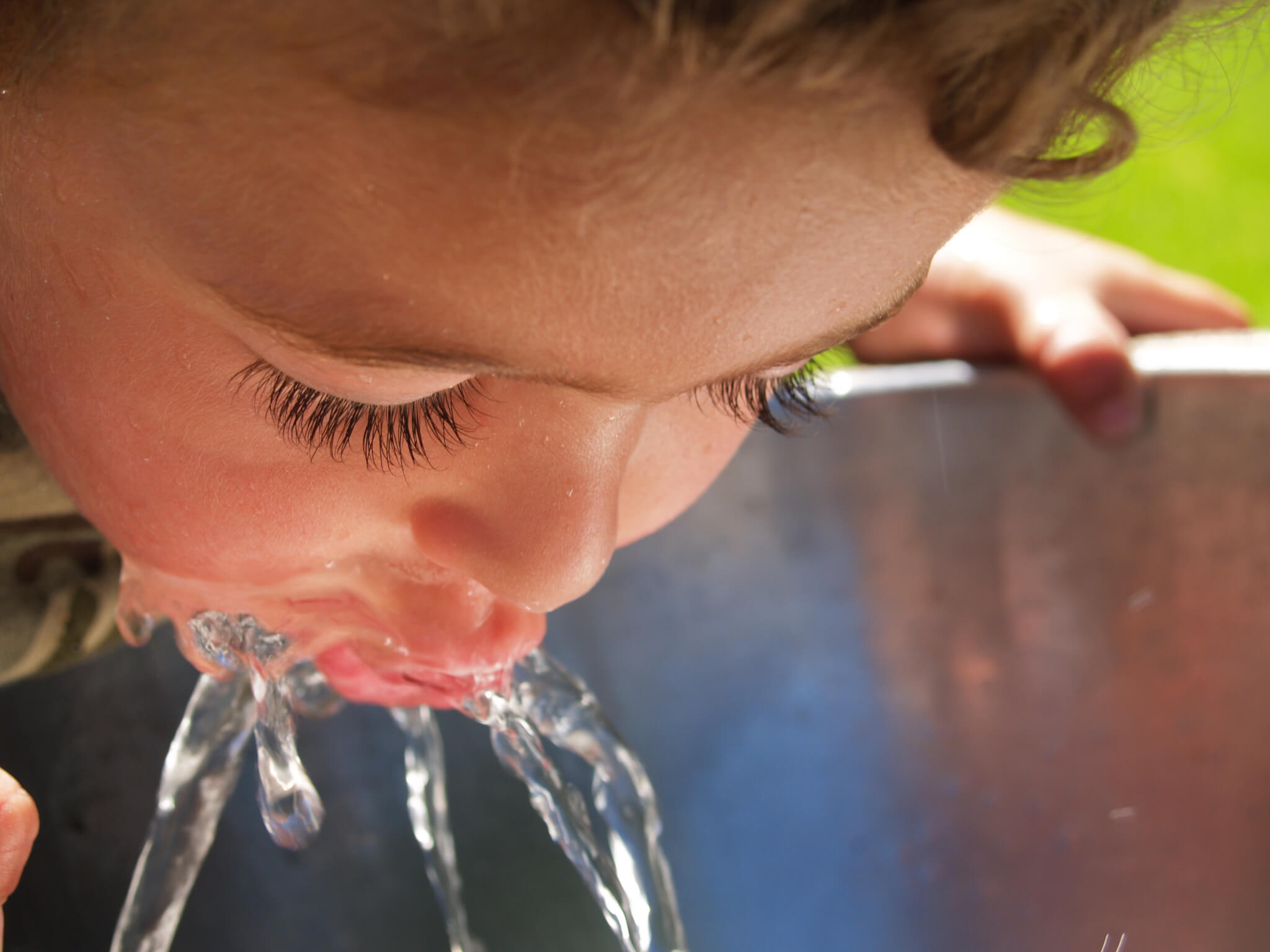 boy drinking water at fountain