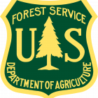 STREAM - USFS US Forest Service logo, a badge shape outlined in yellow with a dark green background and a yellow fir tree in the center. Text reads US Forest Service Department of Agriculture