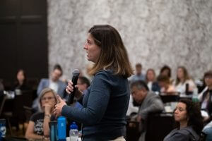 Brenna Goggin holding microphone, speaking at River Rally 2019