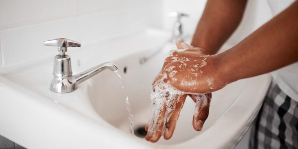 Cropped shot of an unrecognizable man washing his hands in the bathroom at home