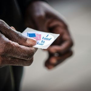 black-mans-hands-holding-i-voted-sticker