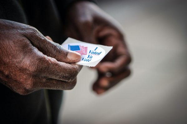 black-mans-hands-holding-i-voted-sticker