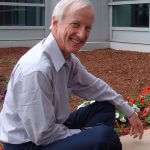 Bob Sproull seated in front of a building.