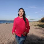 Carla Rodrigo (she/her) standing on a beach.