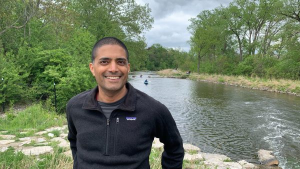 Raj Shukla standing in front of the Huron River in Ann Arbor, Michigan.