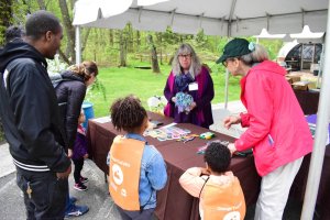 Adults and children in Trail Mix vests gathered around a registration table.